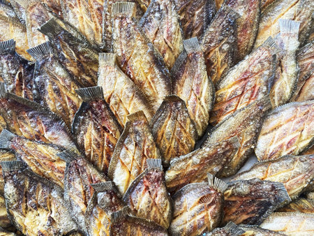 Stack of fired gourami fish (Thai name called "Salid" fish) are selling at local food market. Ready to eat.の写真素材