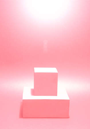 Photo of a bright podium (pedestal) of two cubes on a paper background. In pink, with gradient and glare. Advertising place. Blank product stand and abstract background with light.の写真素材