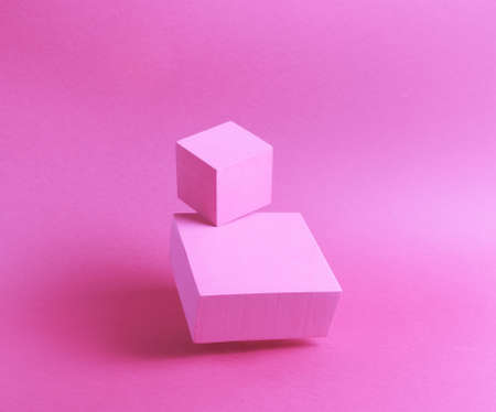 Photo of a bright podium (pedestal) of two cubes on a paper background. In pink, with gradient and levitation. Advertising place. Blank product stand and abstract background with light.の写真素材