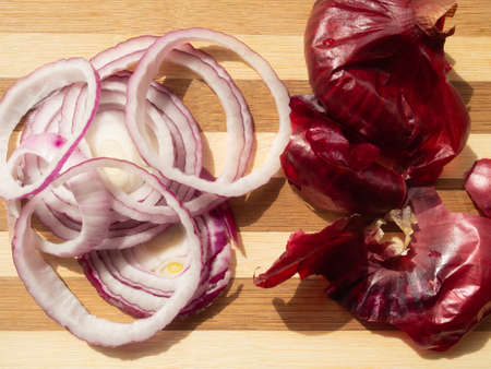 Red onion sliced in rings on a wooden board, top view.の写真素材