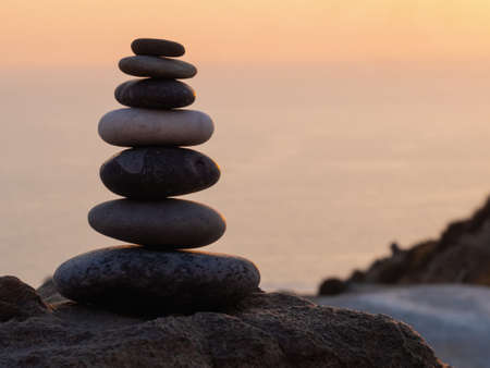 cairn at sunset, stones balances, pyramid of stones at sunset, concept of life balance, harmony and...