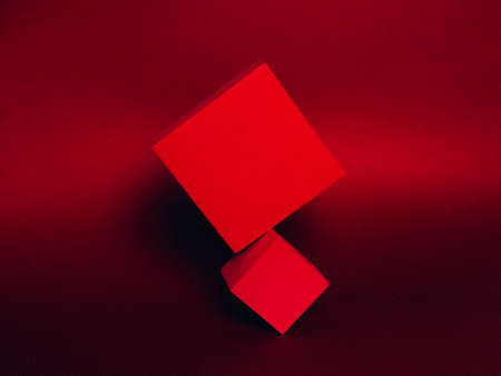 Photo of a bright podium (pedestal) of two cubes on a paper background. In saturated red, with gradient and grain. Advertising place. Blank product stand and abstract background with light. Levitationの写真素材