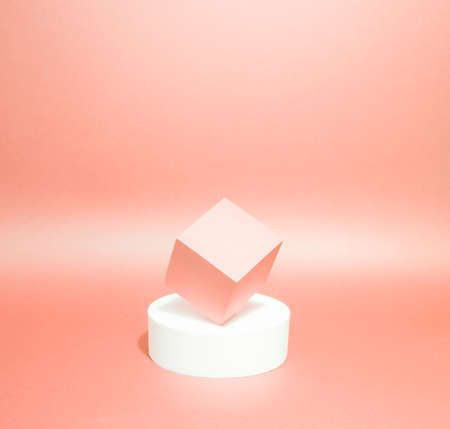 Bright balance of 2 pedestals (cube and round) on a paper background. In peach, with gradient. Advertising place. Blank product stand and abstract background with light.の写真素材