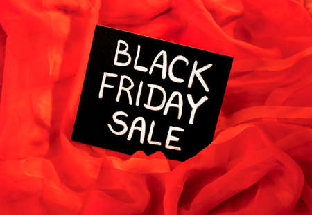 black chalk board with chalk lettering "black friday sale" on a red silk scarfの写真素材