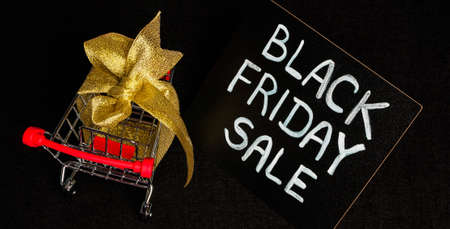 black chalk board with chalk lettering black friday sale on black glitter and supermarket trolley...