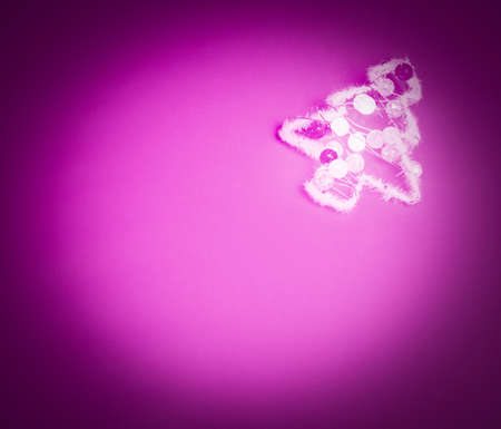 flat lay of white christmas tree wrapped in garland on neon-pink background with circular vignette and copy spaceの写真素材