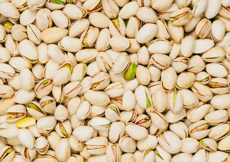 solid background of pistachios, light beige color with green fragmentsの写真素材