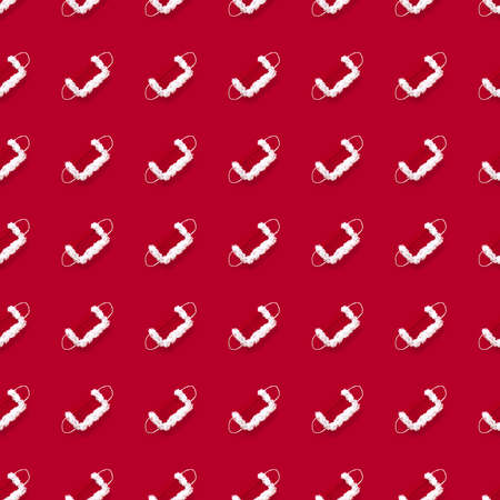 seamless pattern of protective mask for Santa Claus with textured fur, red and white on a red backgroundの写真素材