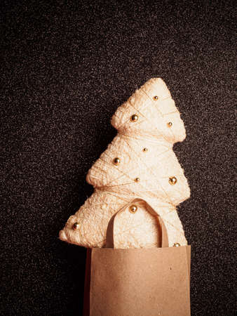 craft bag with golden christmas tree on black glitter backgroundの写真素材