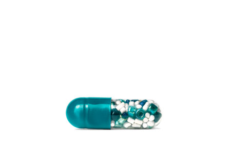 blue medicine capsule with colored small granules and beads inside, isolatedの写真素材