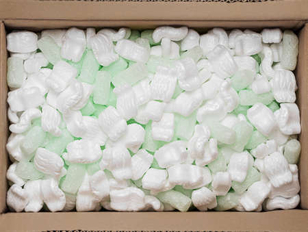 green foam rubber and white  filler into a cardboard box