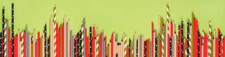 banner of multicolored paper straws for drinks on a green background, copy spaceの写真素材