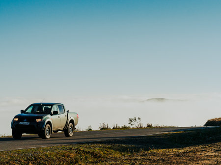 North Caucasus, Russia - September 8, 2021: road high in the mountains, above the clouds. A Mitsubishi car is driving along the road.のeditorial素材