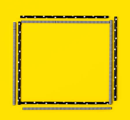 square frame made of paper tubes for cocktails on bright yellow background, copy space