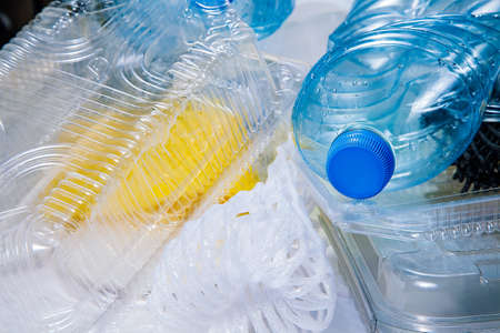 A pile of plastic garbage, close-up - plastic water bottles, takeaway food packages, cans, bags, a...