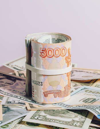 A bundle of Russian paper money in denominations of 1 and 5 thousand rubles, rolled up, lies over...