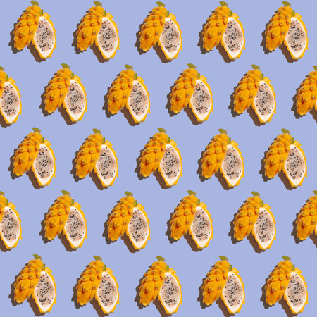 Ripe yellow pitahaya, dragon fruit, cut in half. Seamless tropical pattern of yellow pitahaya on a...