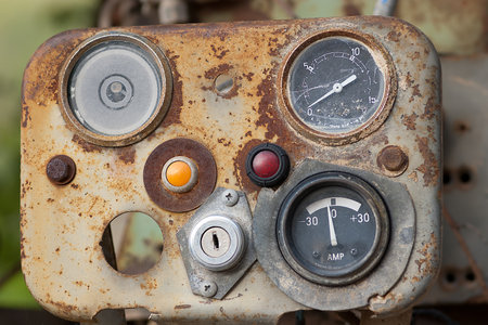 A weathered control panel with various dials and buttons displays signs of rust. Its textures and...