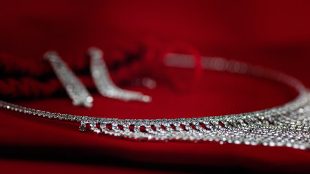 Set of jewelry - earrings and necklace, close-up, on red velvet. Imitation diamonds. Shallow depth...