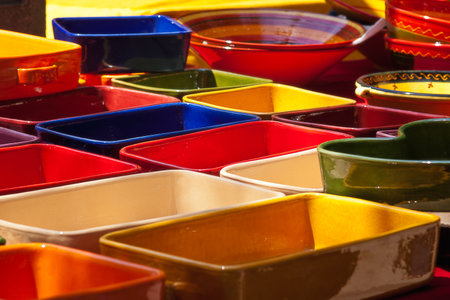 A lively assortment of ceramic bowls displayed with various colors and shapes. Bright reds, blues,...