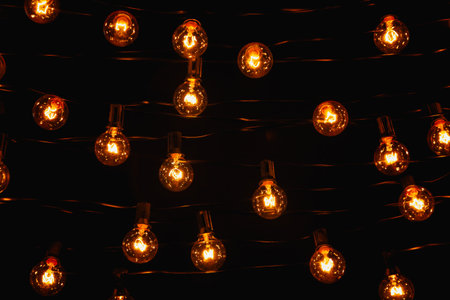 Background - electric garland with incandescent bulbs, yellow warm light, retro styleの写真素材