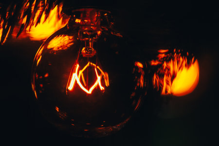 Incandescent bulb of electric garland in retro style, extreme close-up, warm yellow light, Christmas...