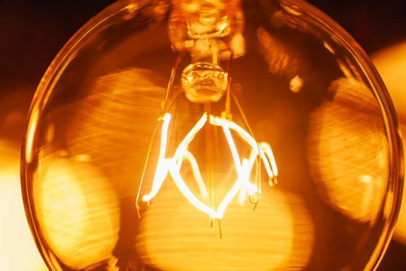 Incandescent bulb of electric garland in retro style, extreme close-up, warm yellow light, Christmas atmosphereの写真素材