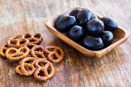 Plate of fresh black olives on wooden surfaceの写真素材