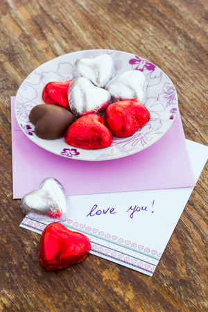 Card with Message Love You in a letter and chocolate candyの写真素材