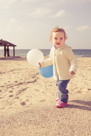 Cute little girl playing on a beachの写真素材