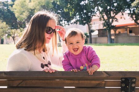 Happy mother and daughter are playing at a park, selective focusの写真素材