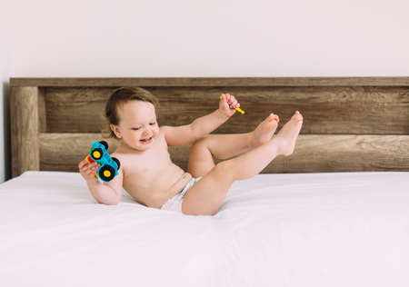 Cute little boy having fun in white sunny bedroom.の写真素材