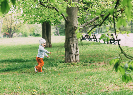 Cute smiling little boy plays in the spring park. Toned image.の写真素材