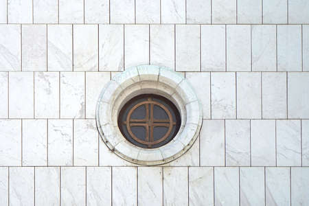 Round window at white marble wall of churchの写真素材