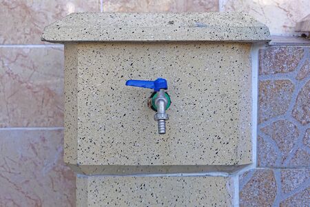 Water faucet with blue handle and hose attachmentの写真素材