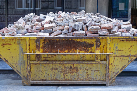 Over filled skip container with brick debrisの写真素材