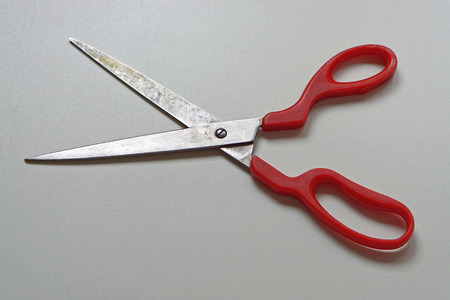 Long scissors with sharp edge and red handlesの写真素材