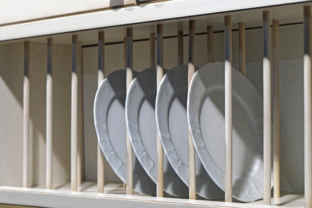 Ceramic dishes in rack shelf at homeの写真素材