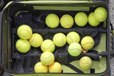 Several used green tennis balls in suitcaseの写真素材