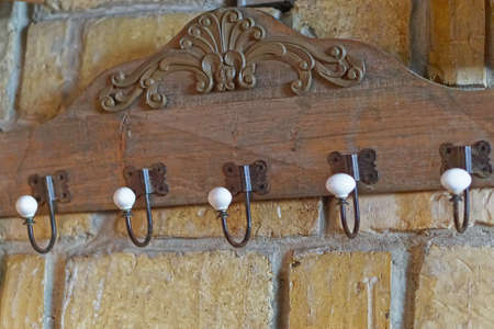 Vintage style coat hooks at old brick wallの写真素材