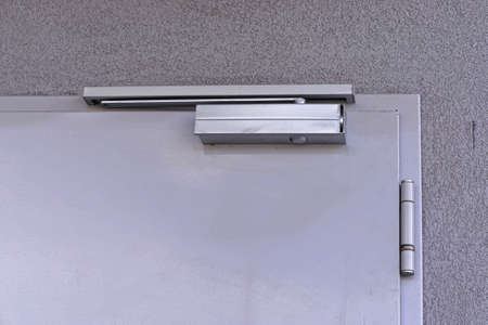 Automatic closer device at top of door