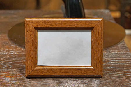 Horizontal empty wooden picture frame at desk