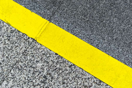 Diagonal yellow line at marble floor caution signの写真素材