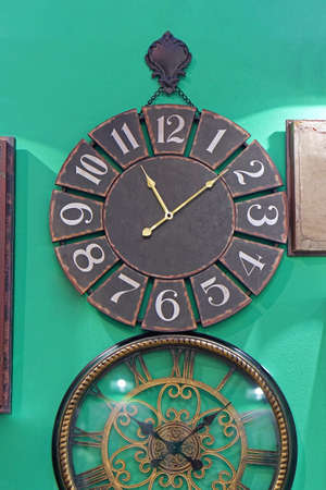 Big vintage round clock at green wall