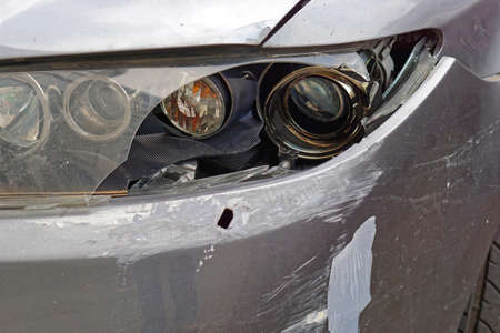 Damaged car broken headlights front bumper traffic accident