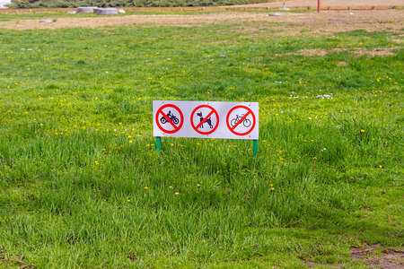 Restrictions warning signs board at green grass in parkの写真素材