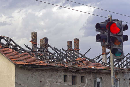 Burned roof at house fire damage danger red traffic light