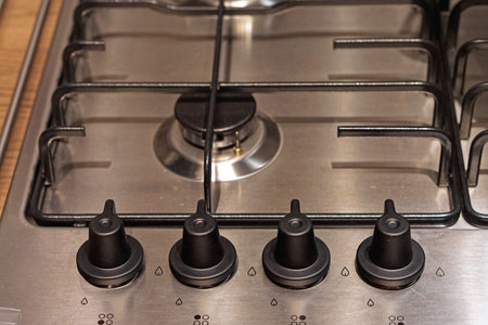 Four controls buttons at gas burning stove top kitchen