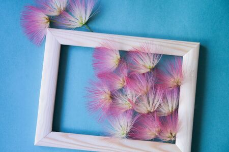 wooden frame with beautiful pink fluffy flowersの写真素材