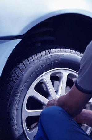 Replacement and maintenance of car tires, closeup of a man from the back. Car service.Image